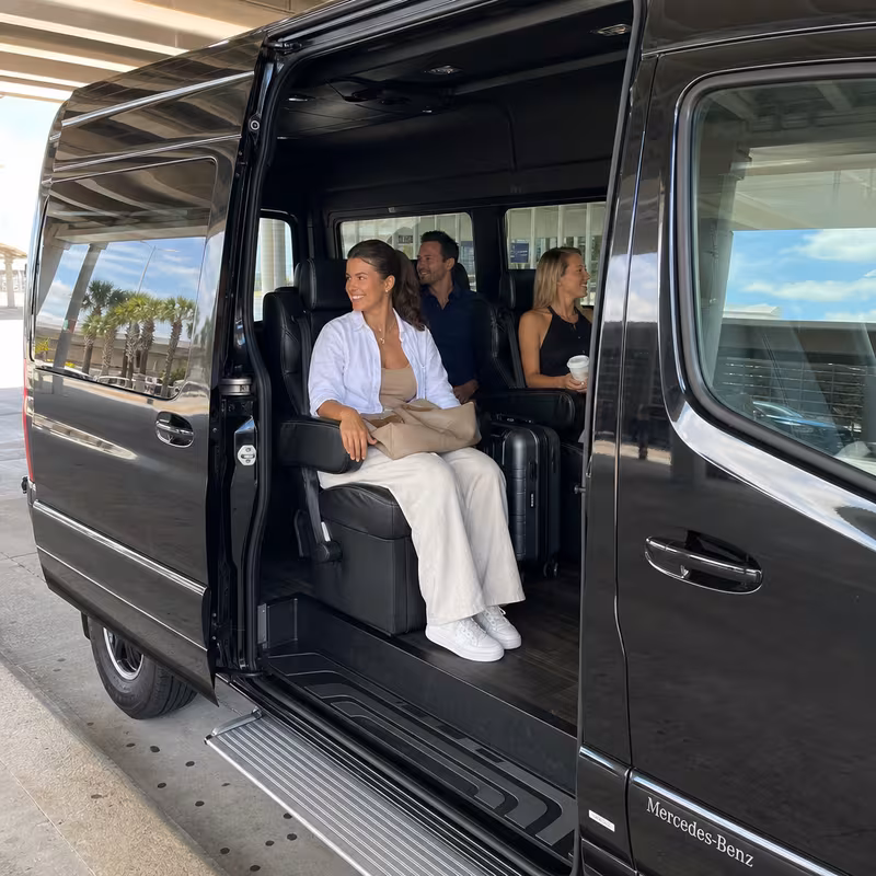 Passengers loading luggage while boarding an Orlando group shuttle