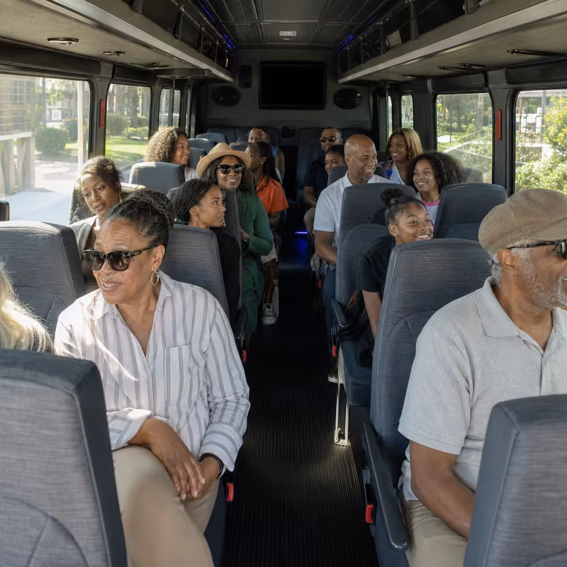 Group boarding a white charter bus for Private Event Transportation transportation in Orlando