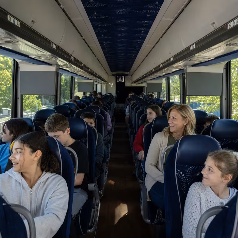 Group boarding a white charter bus for School Transportation transportation in Orlando