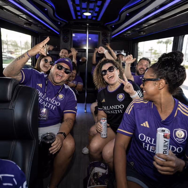 Group boarding a white charter bus for Sporting Event Transportation transportation in Orlando